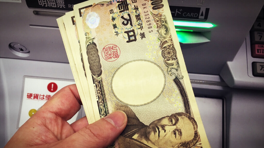 ATMで3万円を引き出した人の手