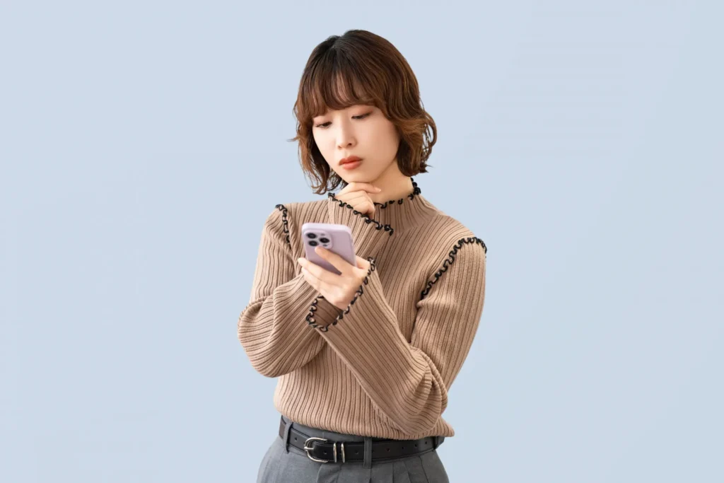 スマホを見て考える女性